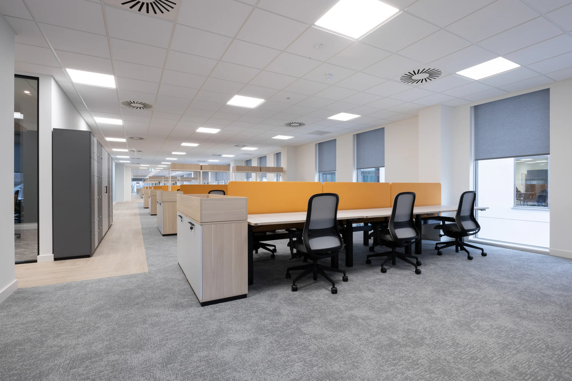 An open-plan workplace with yellow acoustic screens completed by POS Interiors at Plaza House